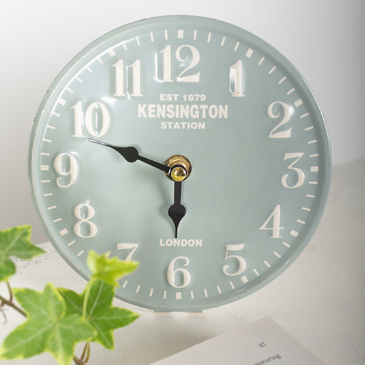 Wall clock with 'Kensington Station' branding on a light background
