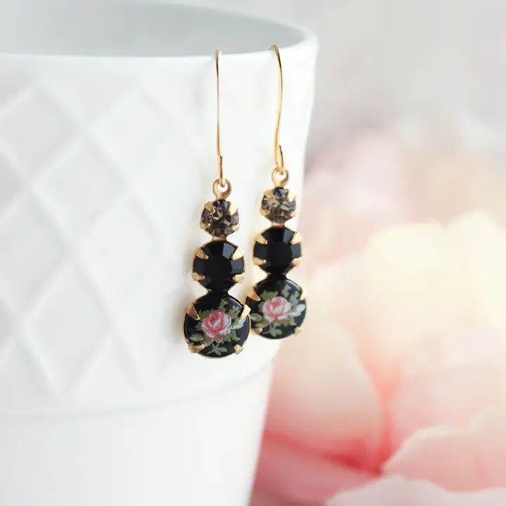 Black floral earrings on a white background