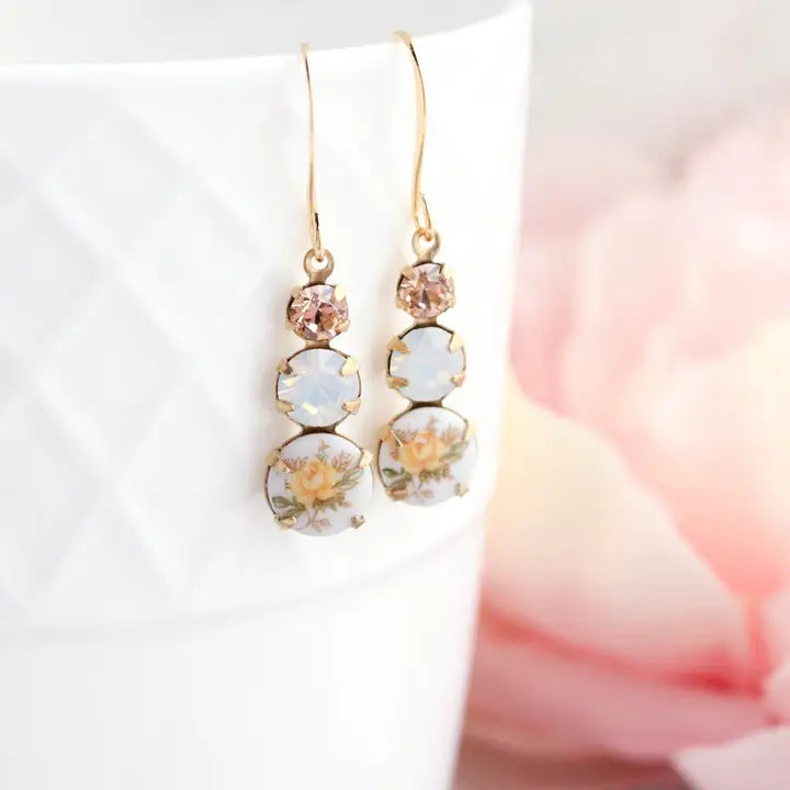 Gold earrings with floral designs on a white background